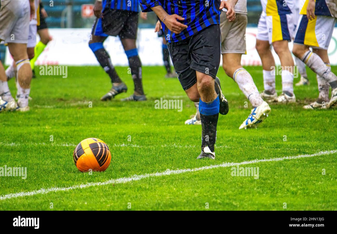 Soccer player running with the ball, other players on the background Stock Photo