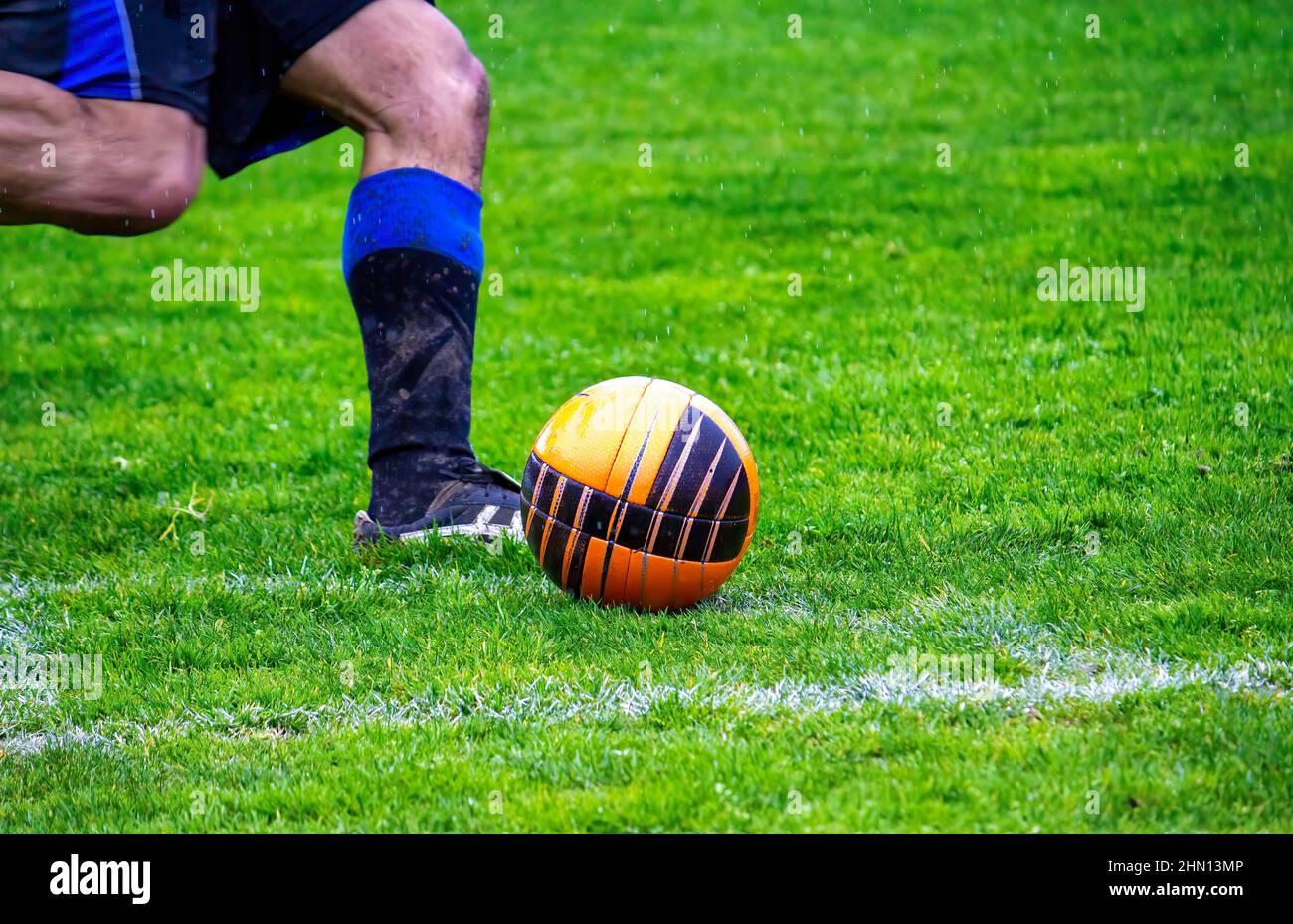 Soccer player kicking the ball from the corner pitch, cross towards the goal Stock Photo