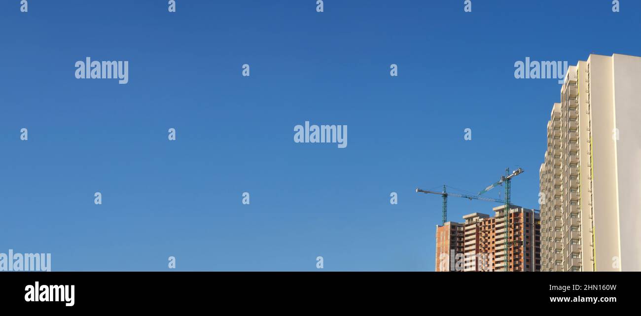 New building construction property banner. Tower cranes construction site building company property background real estate mortgage loan. Investment Stock Photo
