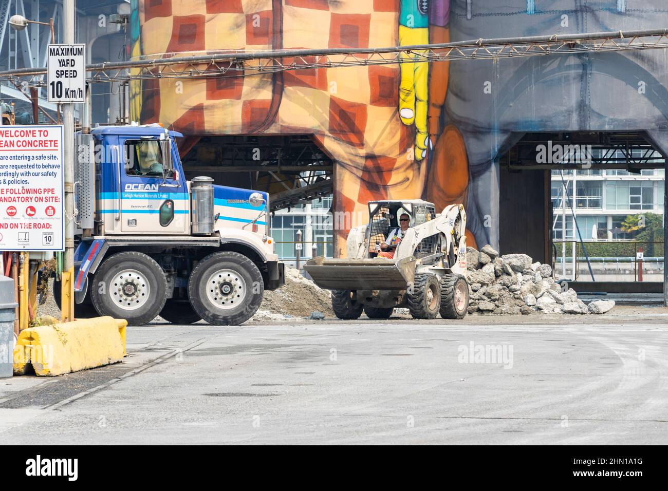 mini excavator bulldozer and cement mixer truck in front of painted