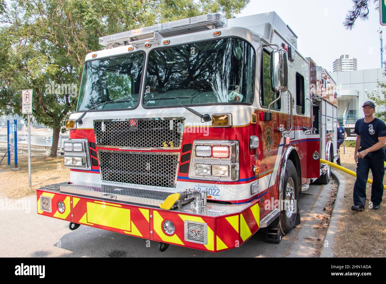 fire crew connect fire engine appliance to a hydrant with hose in Vancouver BC canada Stock Photo