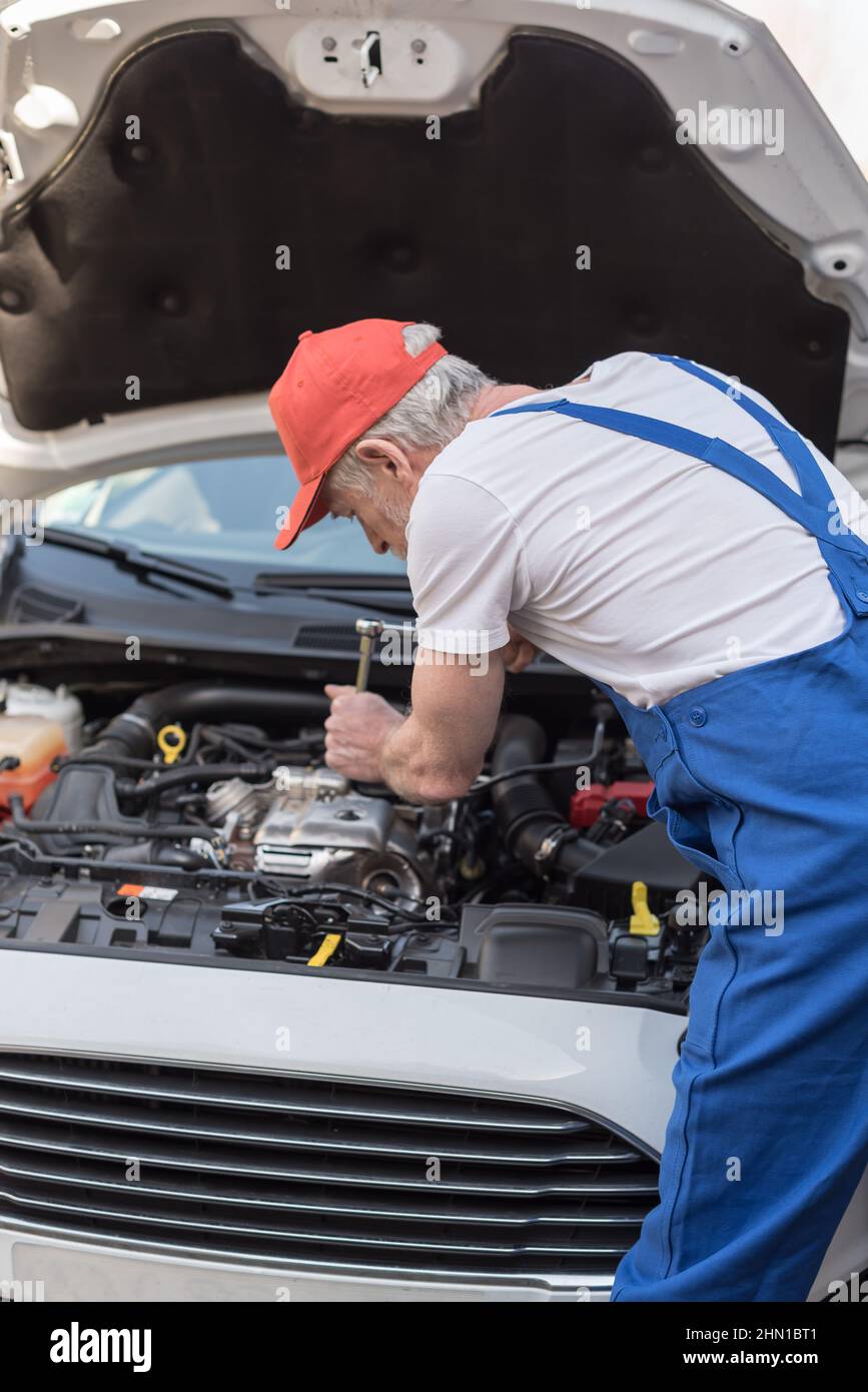 Car mechanic repairing a car engine Stock Photo - Alamy