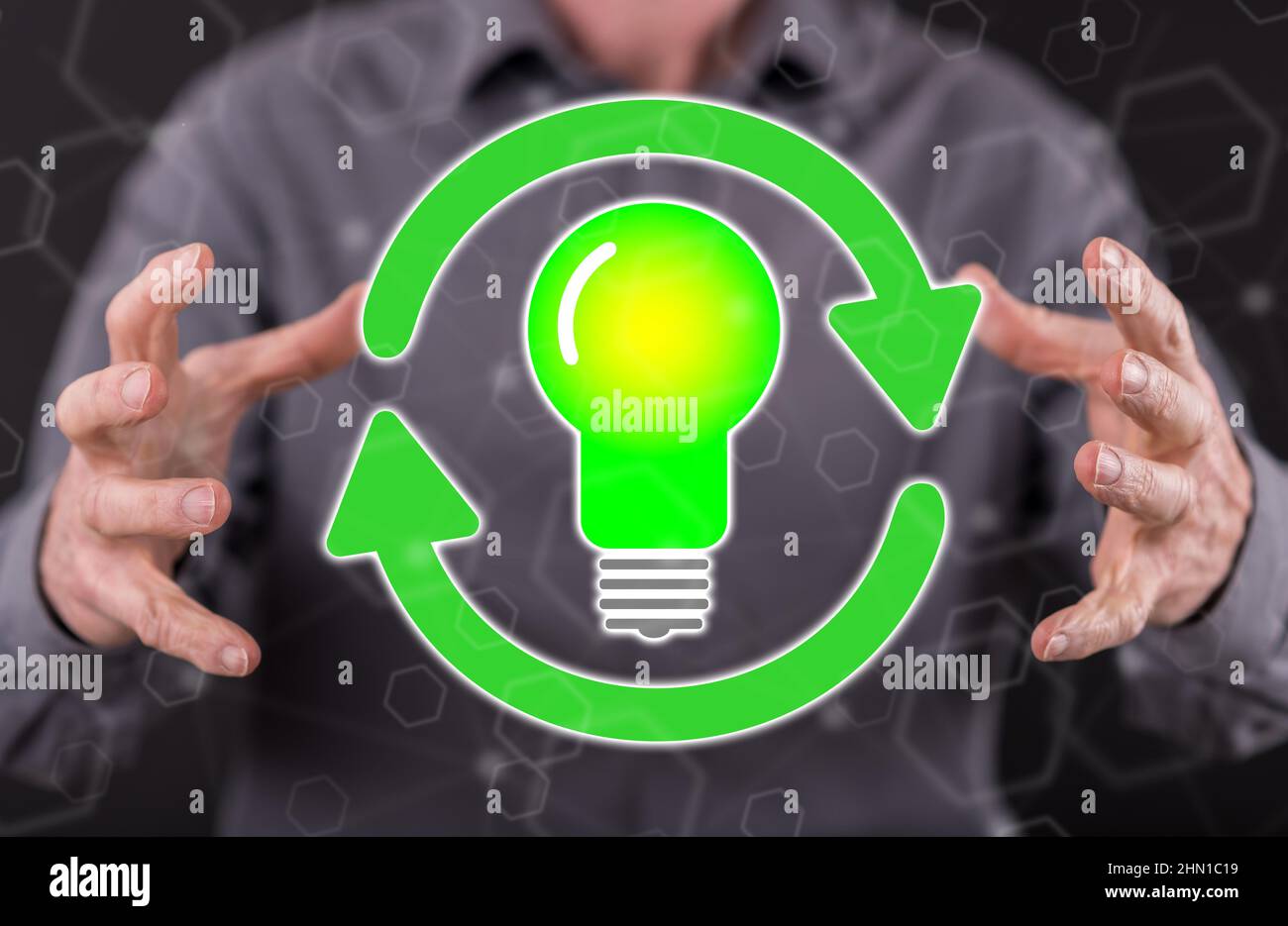 Green energy concept between hands of a man in background Stock Photo Alamy