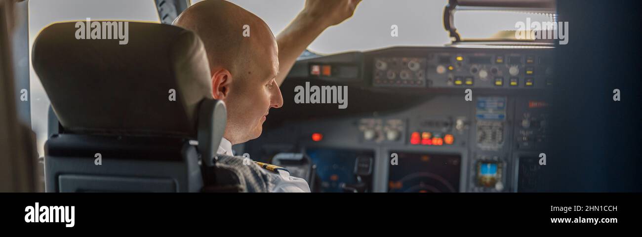 Focused professional pilot sitting in an airplane cabin, ready for takeoff Stock Photo