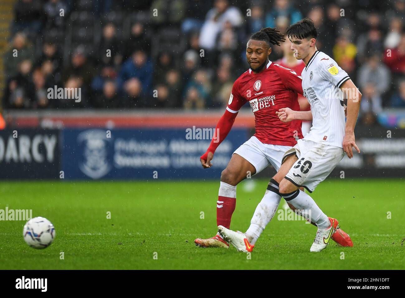 Swansea, UK. 13th Feb, 2022. Finley Burns #30 of Swansea City under pressure from Antoine Semenyo #18 of Bristol City in Swansea, United Kingdom on 2/13/2022. (Photo by Mike Jones/News Images/Sipa USA) Credit: Sipa USA/Alamy Live News Stock Photo