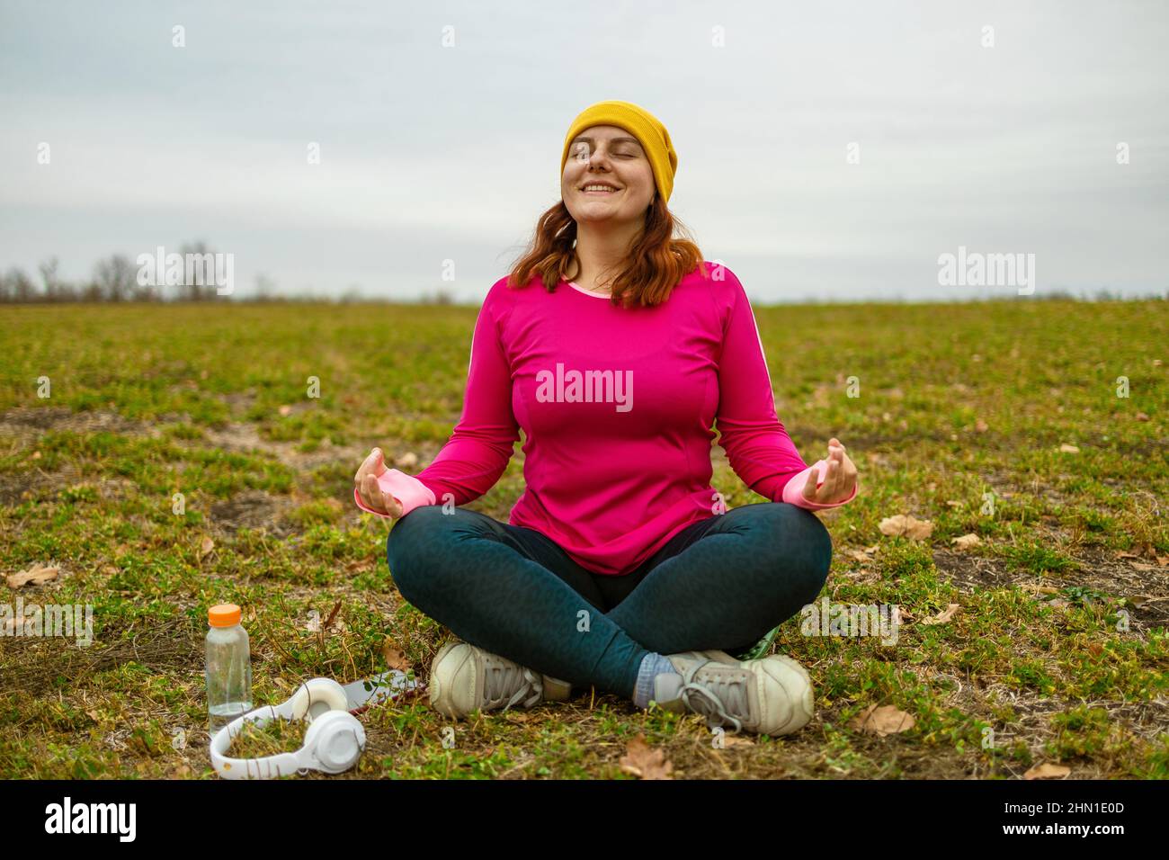 Yoga woman meditating sitting in yoga lotus pose outdoor at sunrise, meditation for balance. Stock Photo