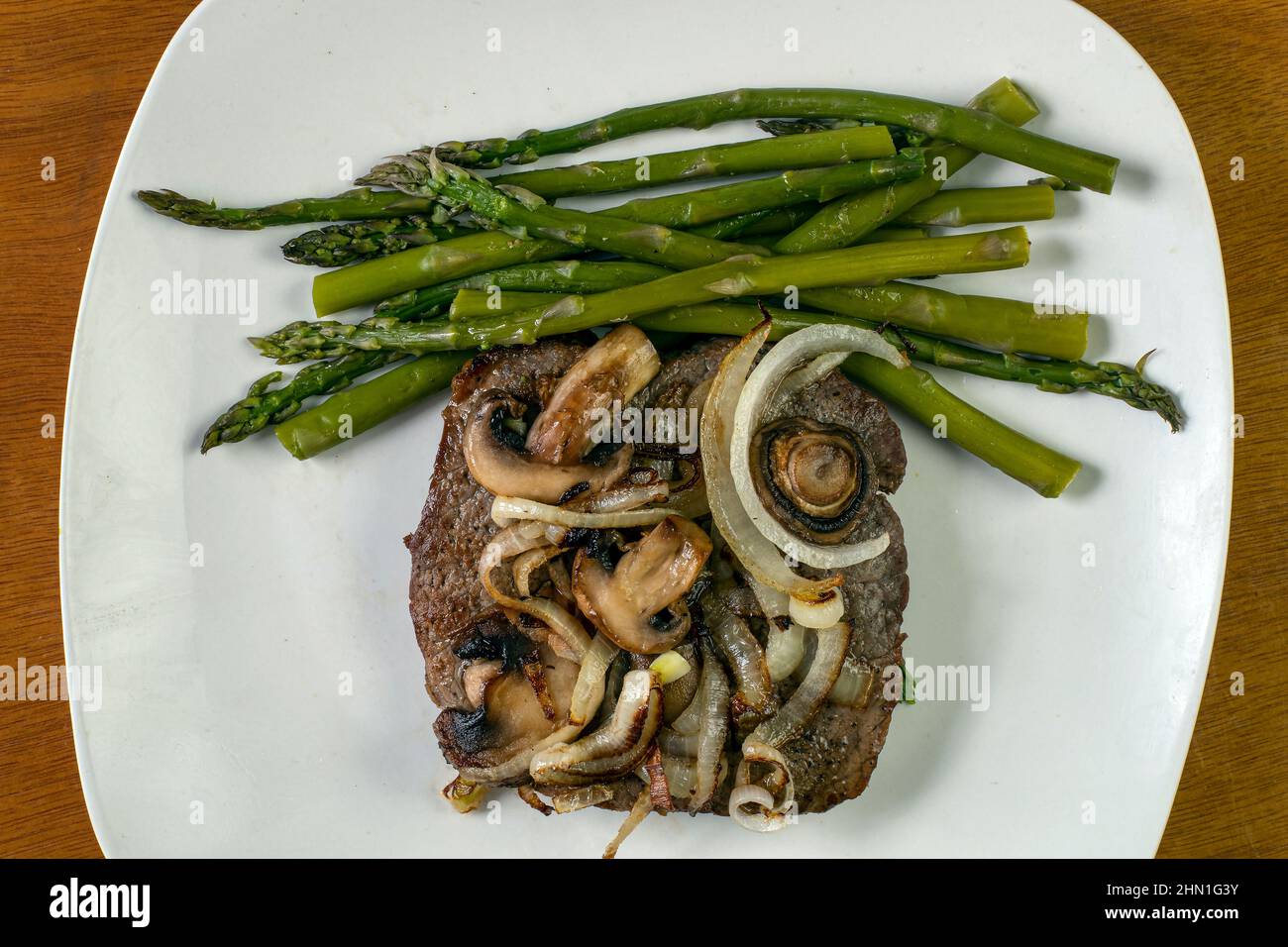 a steak sauteed with onions and mushrooms with asparagus Stock Photo Alamy