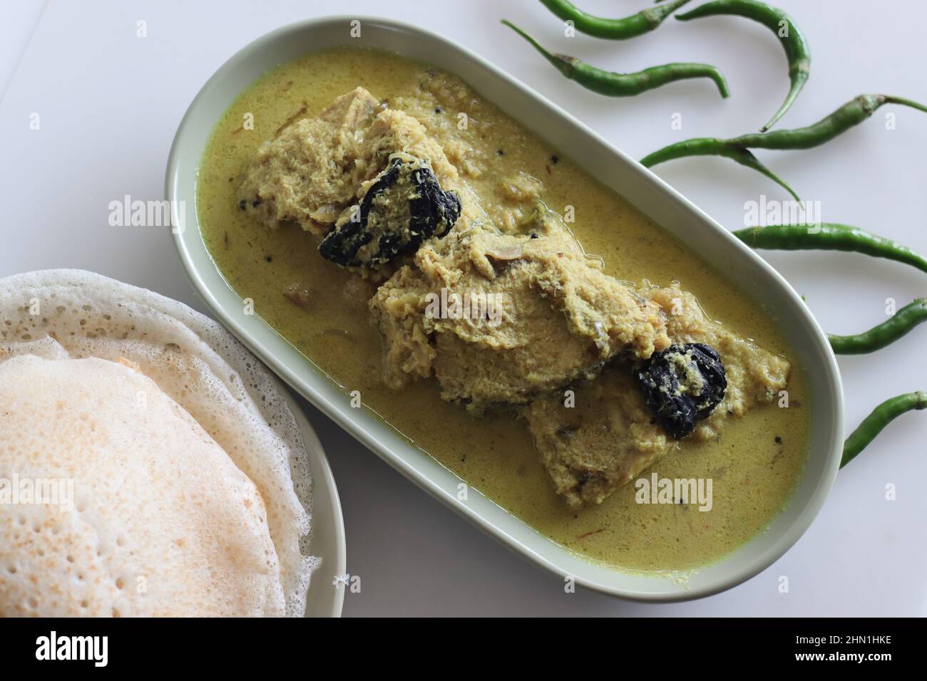 Kerala style, coconut based Pomfret fish curry served with rice hoppers