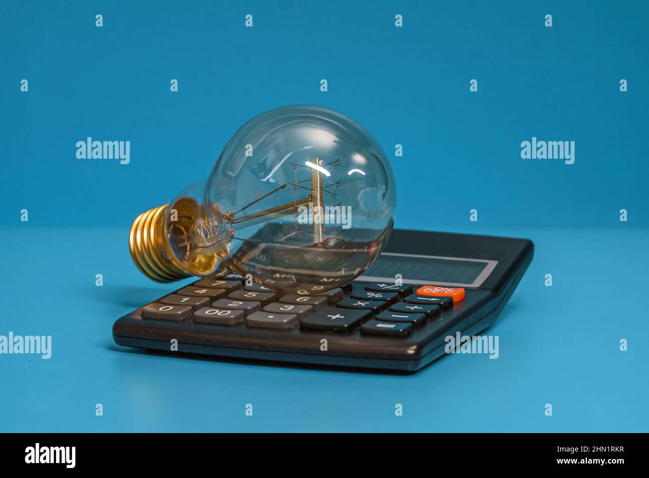 Electricity growth concept. Calculator and light bulb Stock Photo Alamy
