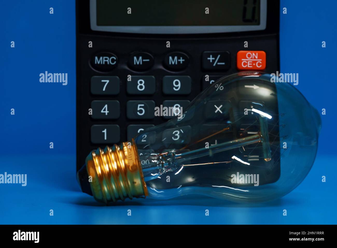 Electricity growth concept. Calculator and light bulb Stock Photo Alamy