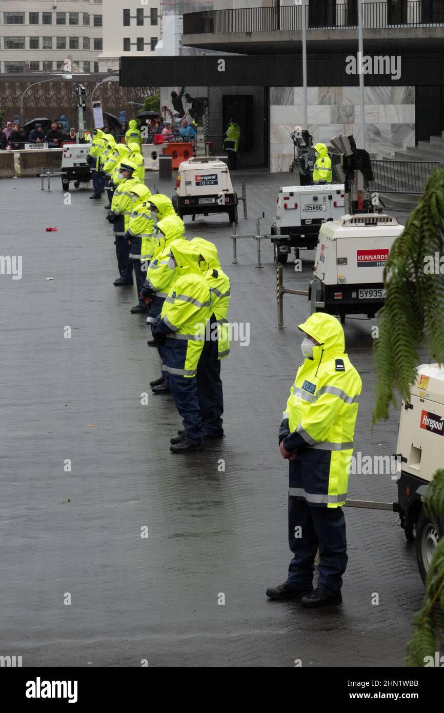 Masked police keep watch at covid vaccine mandate protest outside parliament in Wellington, New Zealand, February 13, 2022 Stock Photo