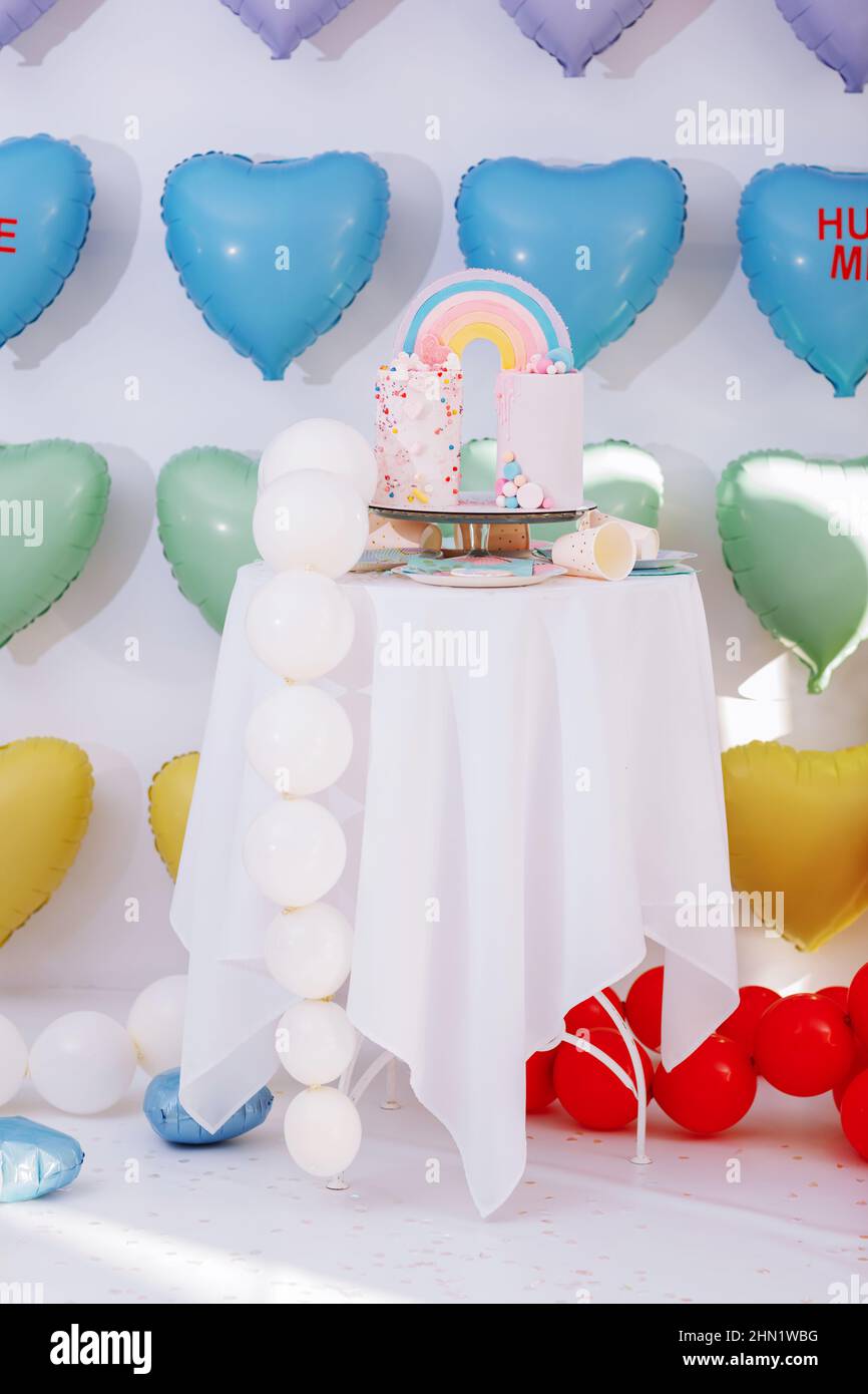 big Birthday cake with rainbow, colorful Sprinkles. on many colorful heart  balloons background. birthday party. sweet holiday Stock Photo - Alamy
