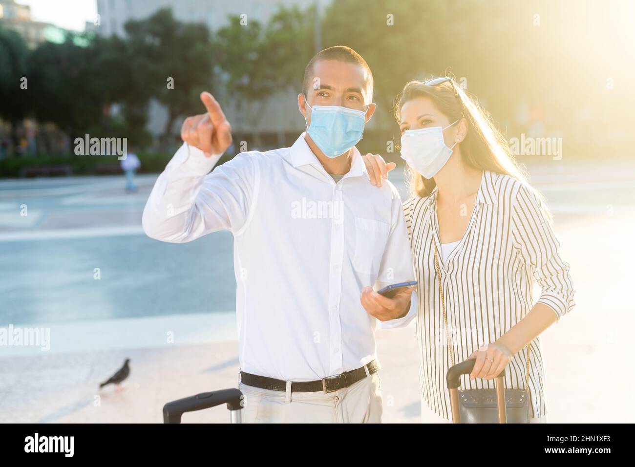 Tourist couple in medical masks visiting city attractions Stock Photo ...