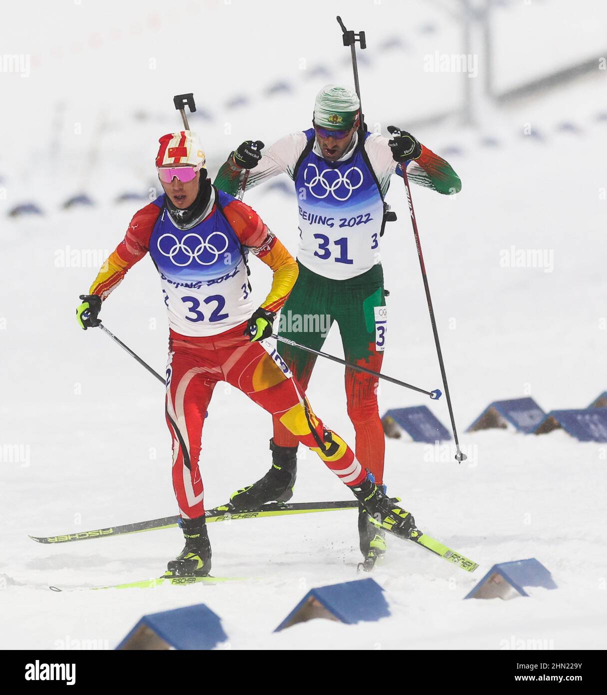 Zhangjiakou, China's Hebei Province. 13th Feb, 2022. Cheng Fangming (L) of China competes during biathlon men's 12.5km pursuit at National Biathlon Centre in Zhangjiakou, north China's Hebei Province, Feb. 13, 2022. Credit: Ding Ting/Xinhua/Alamy Live News Stock Photo