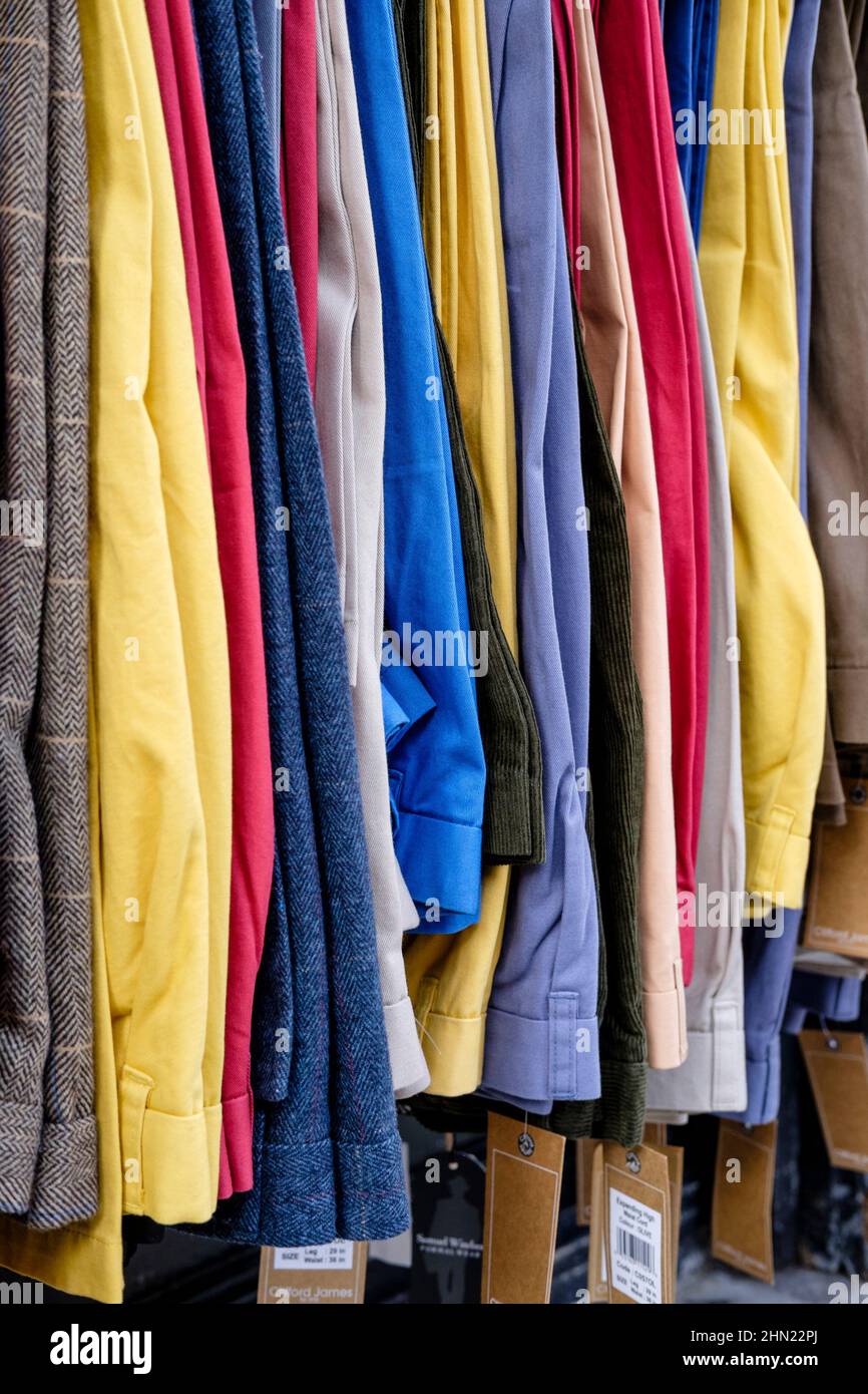 Rail of men's trousers for sale on market stall, east London, UK. Stock Photo