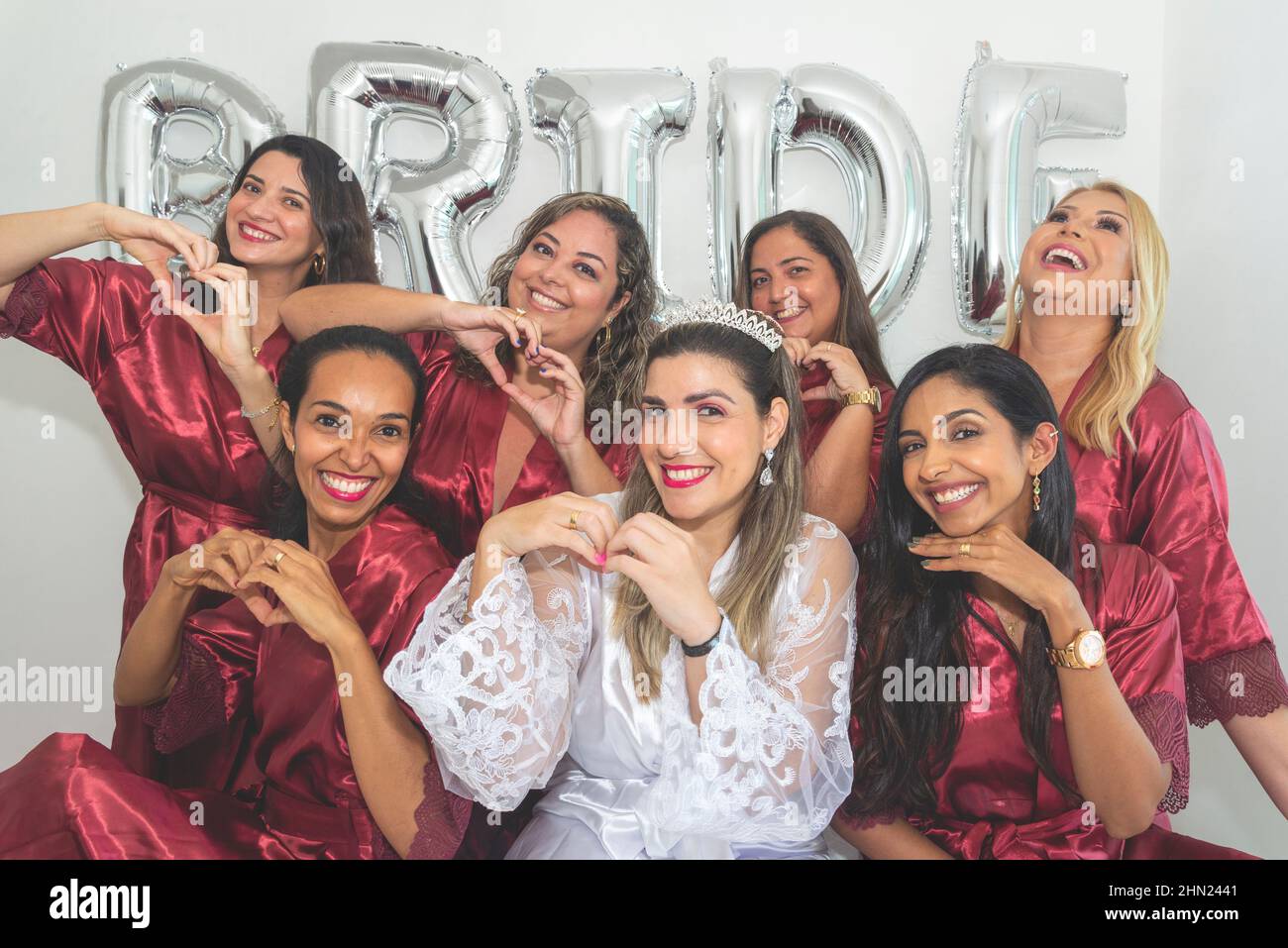 Bride and bridesmaids together in portrait against white background written Bride. Salvador, Bahia, Brazil. Stock Photo