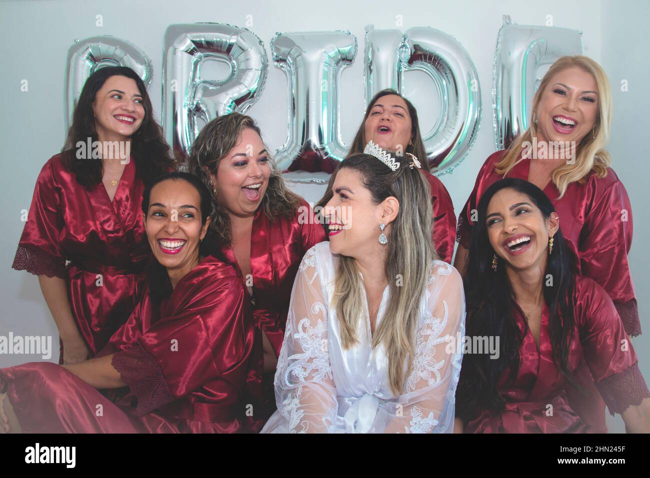 Bride and bridesmaids together in portrait against white background written Bride. Salvador, Bahia, Brazil. Stock Photo