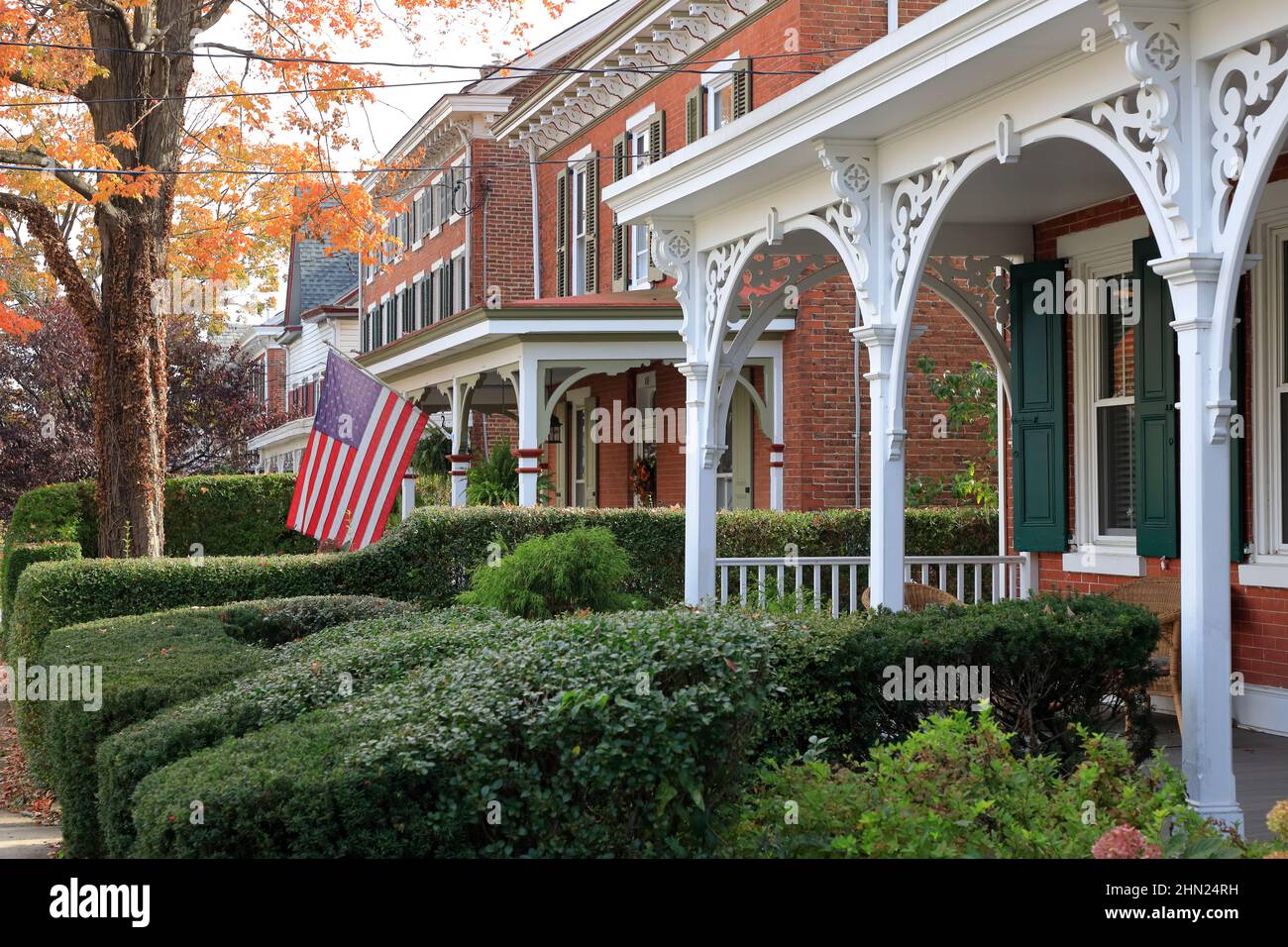Victorian houses with elegant decorated front porch columns and garden