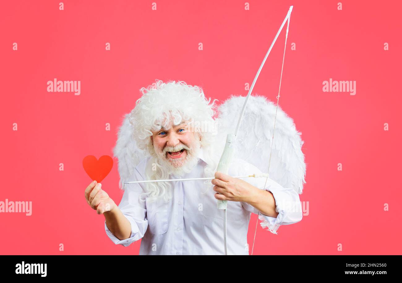 Valentines day. Cupid angel with bow and arrow holds paper heart. Arrow of love. Stock Photo