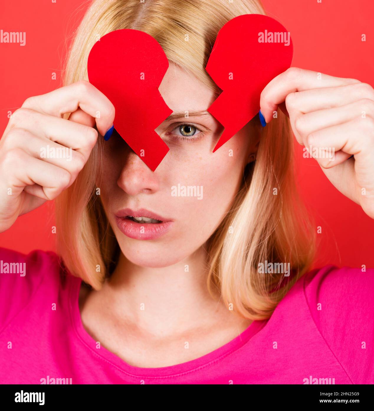 Woman with broken paper heart. Divorce and breakup concept. Relationship problems and lonliness. Stock Photo