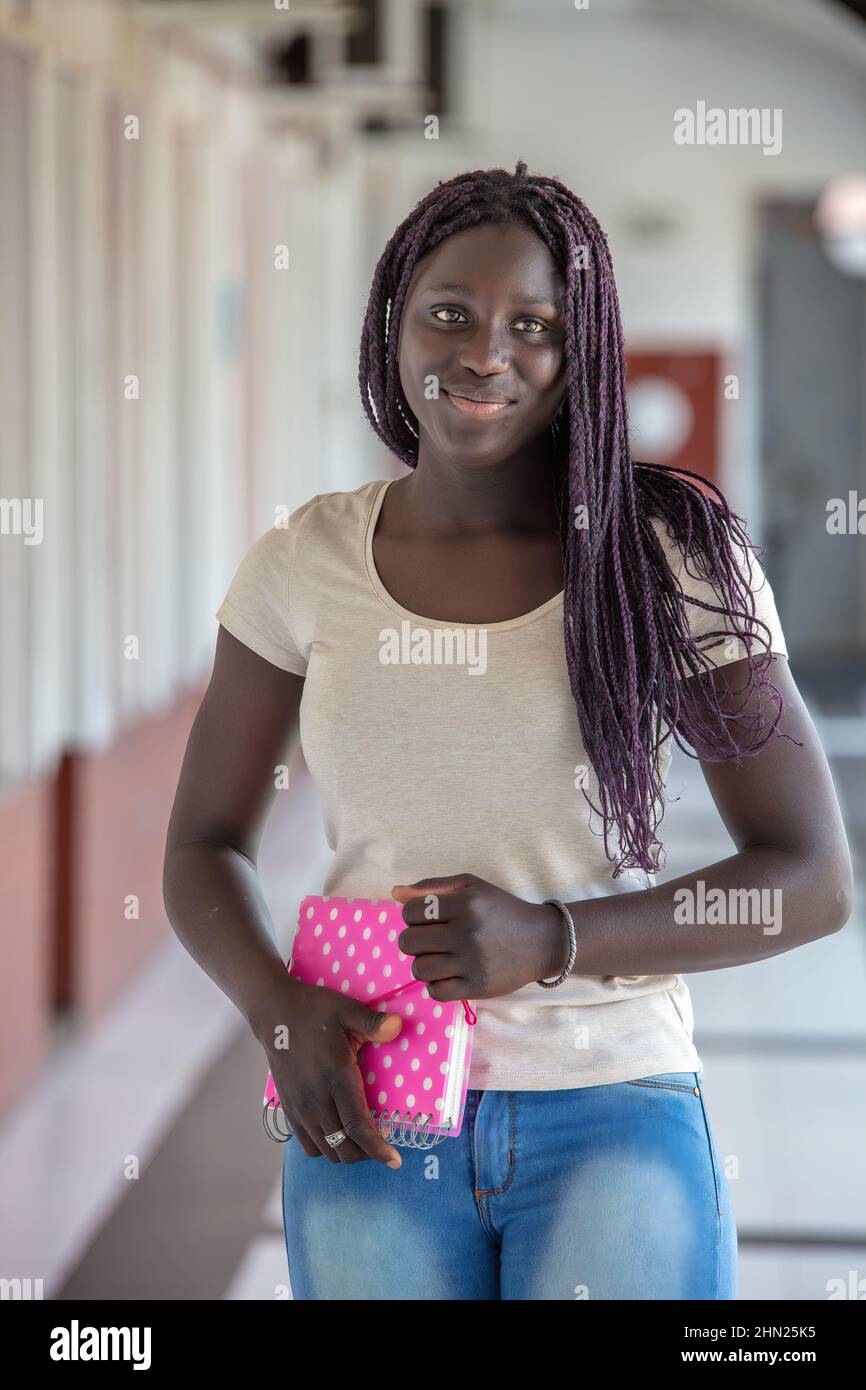 High school african girl smiling and looking to the camera in the hallway Stock Photo