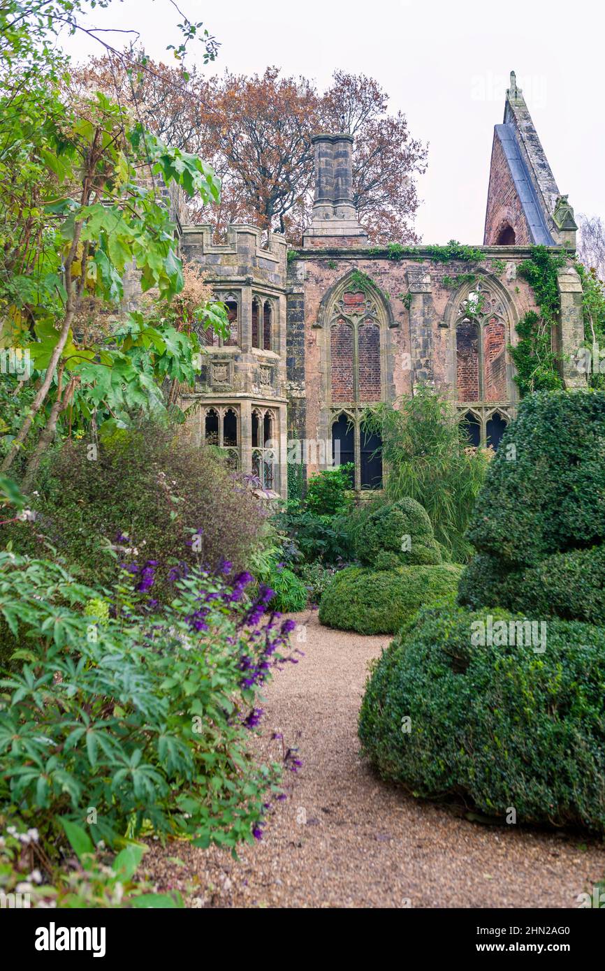The romantic ruins of Nymans, destroyed by fire in 1947, and now surrounded by luxuriant and exotic planting: West Sussex, UK Stock Photo