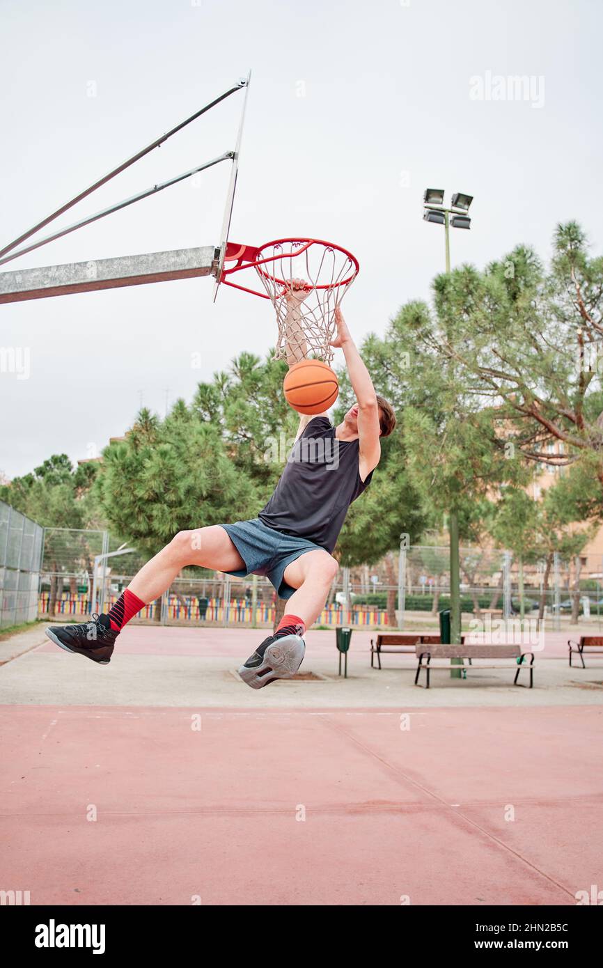 close up of Young Basketball street player making slam dunk Stock Photo