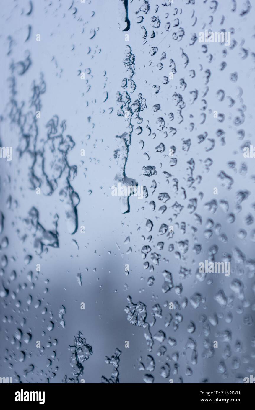 Melting snow on the glass, drops of water condensation on the window