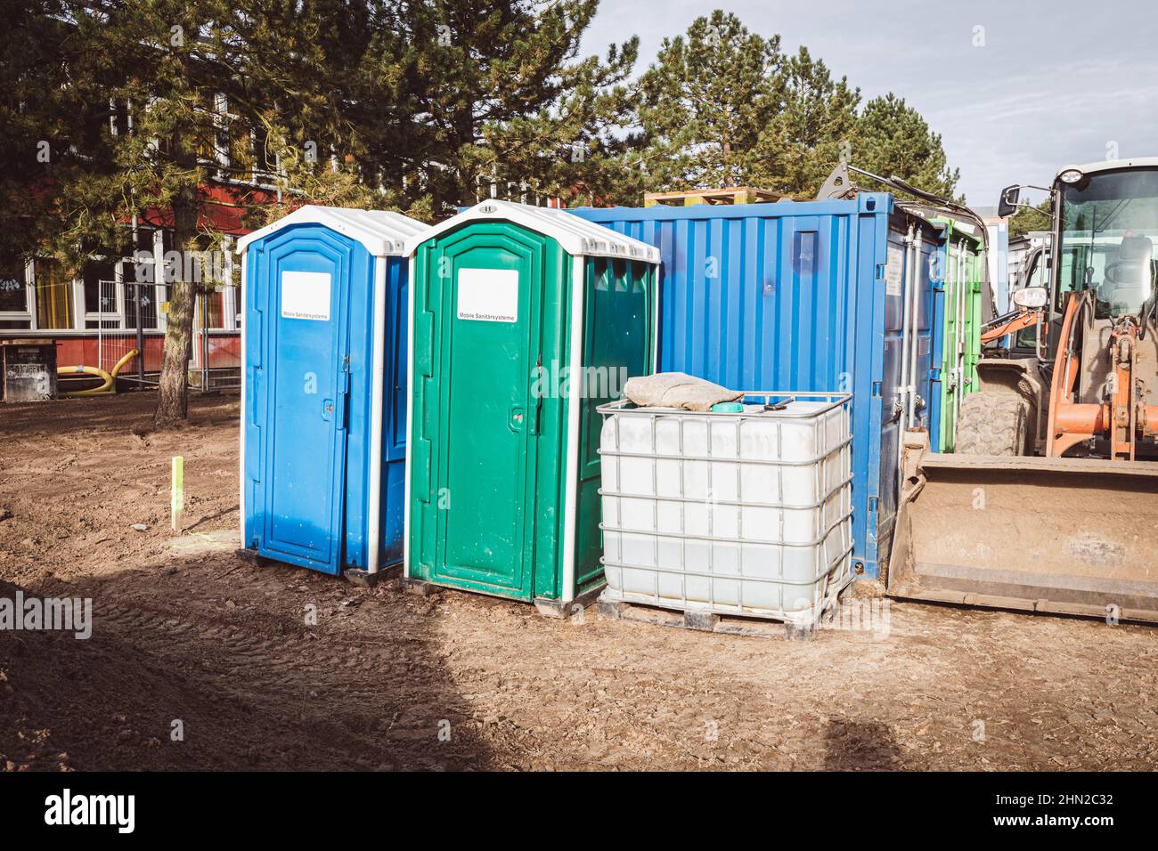 on a construction site there are two construction site toilets, a water