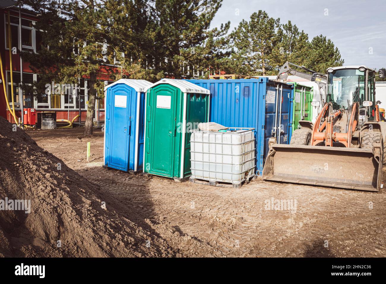 on a construction site there are two construction site toilets, a water