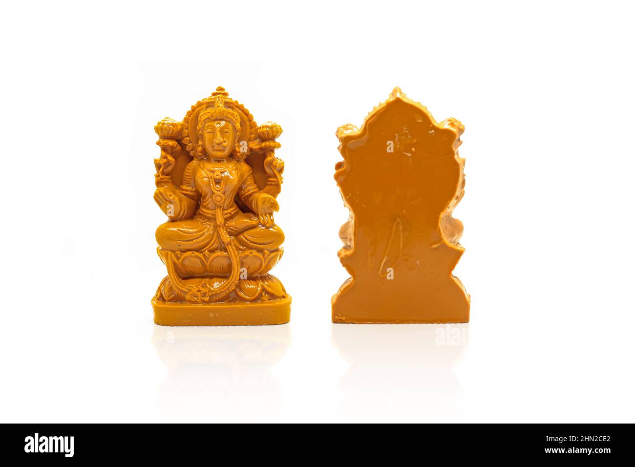 The statue of Mahalakshmi carved in brown wood is isolated with a white  backgrounds with reflection on the front and back Stock Photo - Alamy