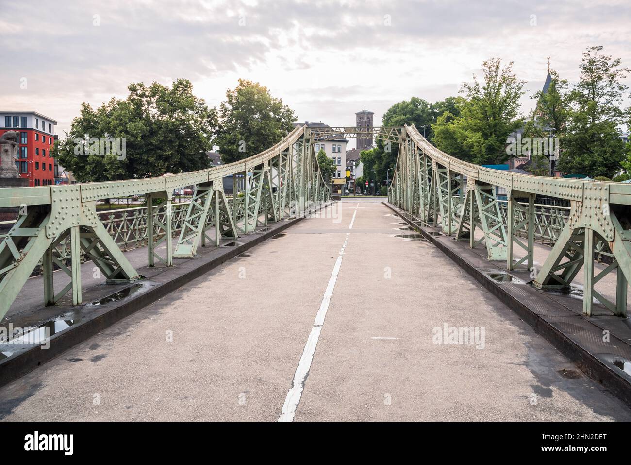 Narrow steel road bridge leading to a residentail district from an old harbour area on a cloudy summer day Stock Photo