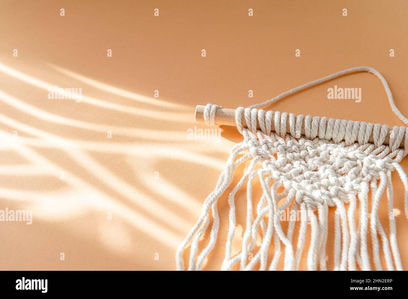 Macrame accessories on beige background. Creative hobby concept. Top view Stock Photo