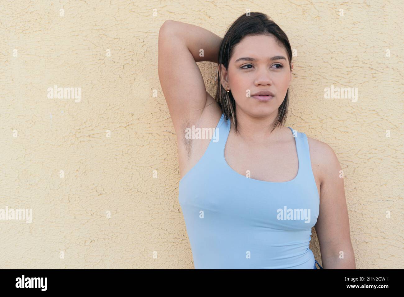 Natural woman with unshaven armpits looking to the side Stock Photo