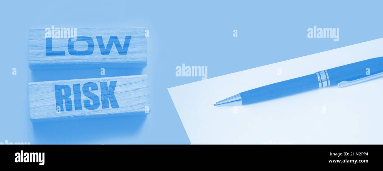 Low risk words wooden blocks on yellow. Business investment risks ...
