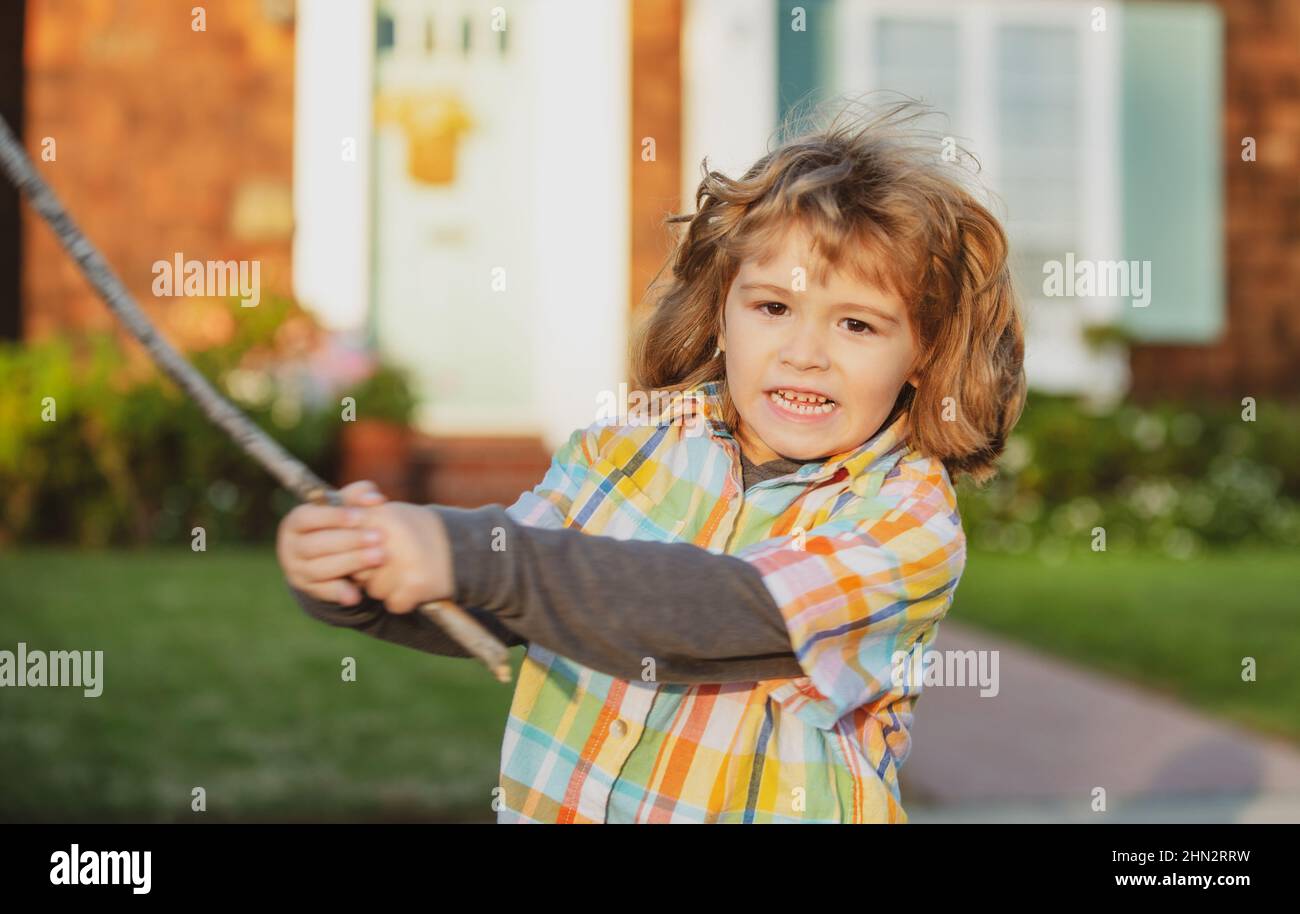 Child aggression. Negative kids emotion. Angry boy with stick. Kid