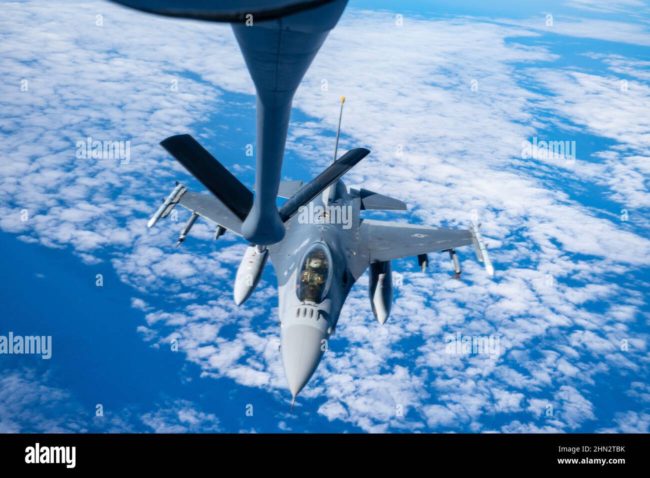 A U.S. Air Force  F-16 Fighting Falcon pilot assigned to the 14th Fighter Squadron conducts aerial refueling with a KC-135 Stratotanker aircraft assigned to the 909th Air Refueling Squadron during exercise Cope North 22 over the Pacific Ocean, Feb. 8, 2022. CN 22 allows each nation to hone vital readiness skills and enhance interoperability among multiple mission areas to include air superiority, interdiction, electronic warfare, tactical airlift, and aerial refueling capabilities. (U.S. Air Force photo by Master Sgt. Joey Swafford) Stock Photo