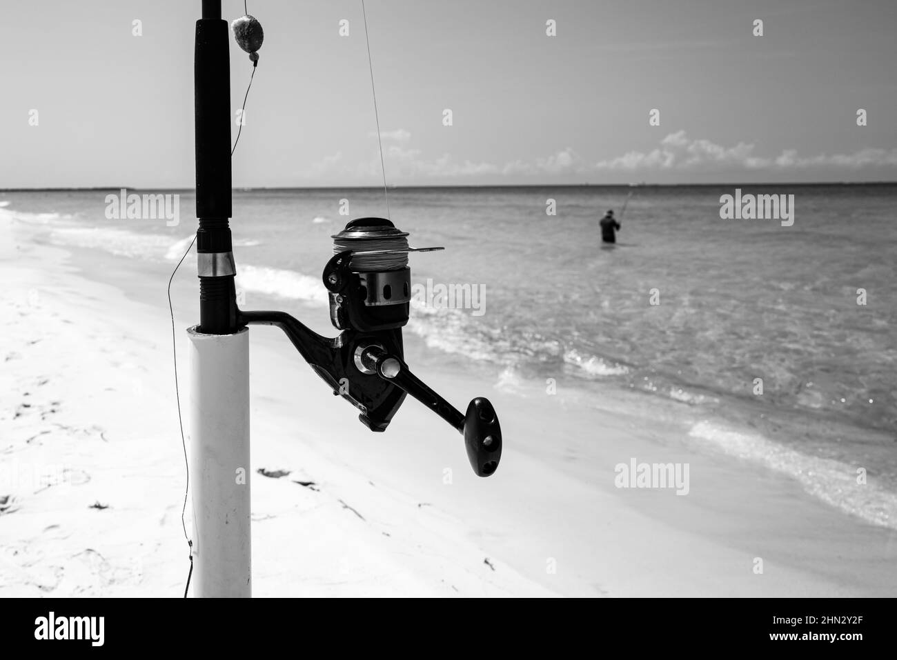Close-up of a fishing reel on sea. Fishing rod and reel on sea and sky. Stock Photo