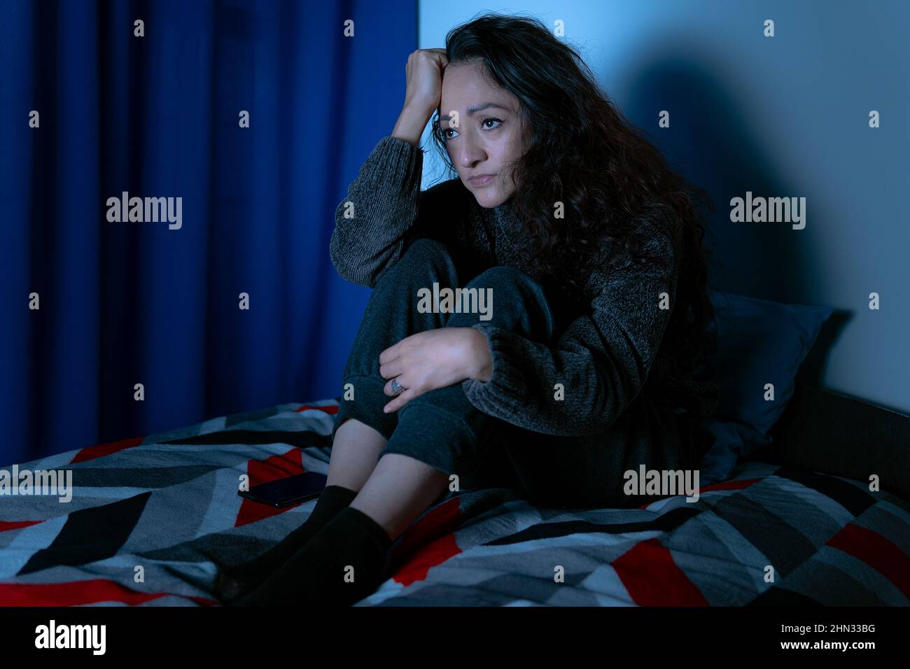 Insomnia, Depressed woman sitting up in bed at night, she can't sleep from insomnia Stock Photo