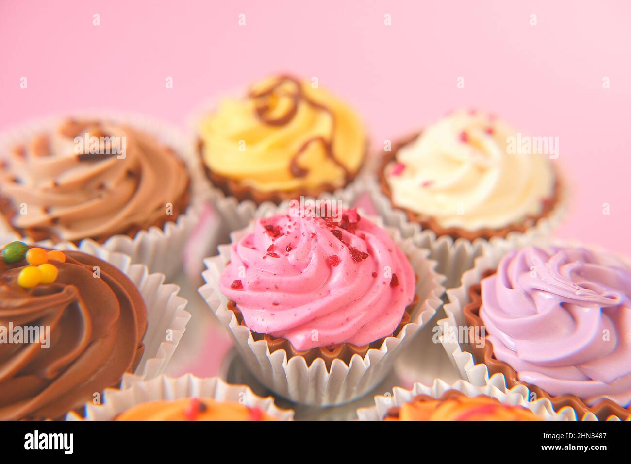 Cream cupcakes.cakes on a pink background.Cream dessert. Assorted sweet
