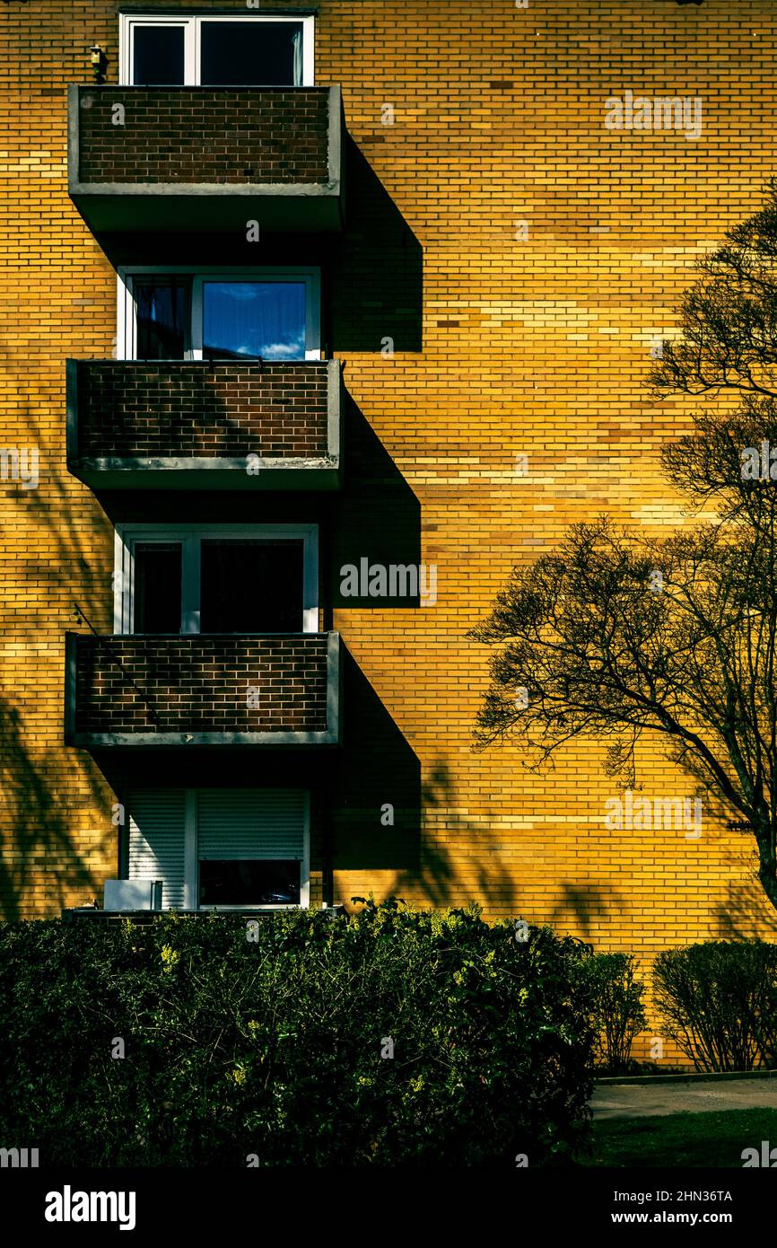 Vertical shot of a modern building facade with three balconies on sunny ...