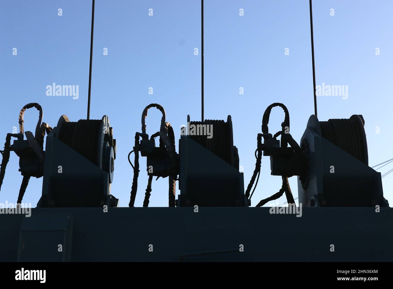 Silhouette of three boat winches,  Monterey Bay harbor, CA. Powerful pulley systems used in the boating industry. Stock Photo