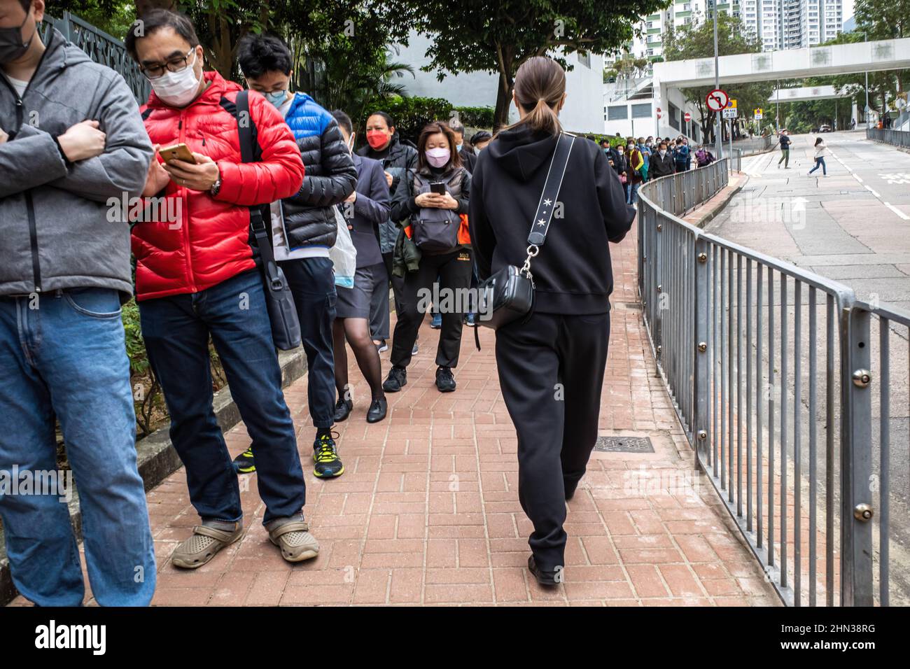 Hong Kong, China. 09th Feb, 2022. Hong Kong residents line up for their COVID-19 test. With the Omicron variant breaking through Hong Kong's 'Zero COVID' containment strategy, tens of thousands of Hongkongers have queued in recent days to be tested, many under Compulsory Testing Notices issued by the Centre for Health Protection. Credit: SOPA Images Limited/Alamy Live News Stock Photo