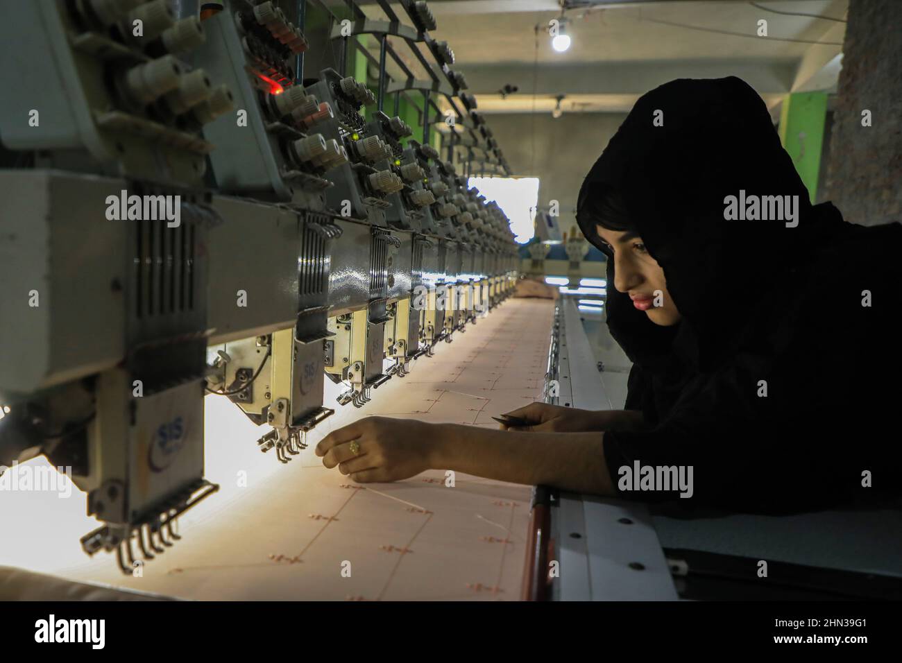 Dhaka, Bangladesh. 12th Feb, 2022. A woman seen working at an embroidery machine in a textile factory at Kamrangirchar. Credit: SOPA Images Limited/Alamy Live News Stock Photo