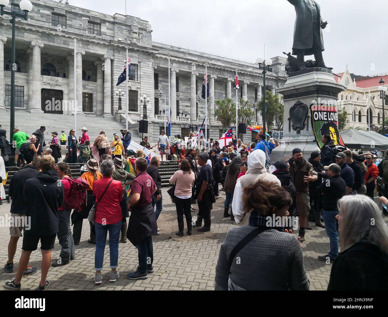 Crowd of people protesting covid vaccine mandates in front of parliament in Wellington, New Zealand Stock Photo