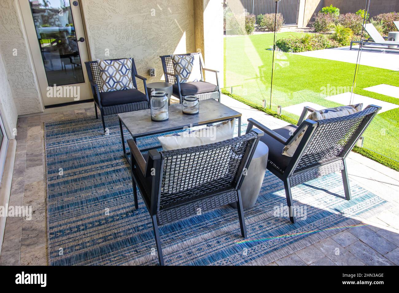 Back Patio With Four Arm Chairs And Coffee Table On Decorator Rug Stock Photo