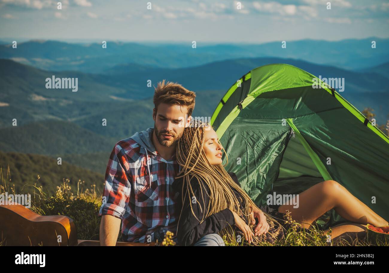 Romantic couple camping outdoors and sitting near tent. Happy Man and ...