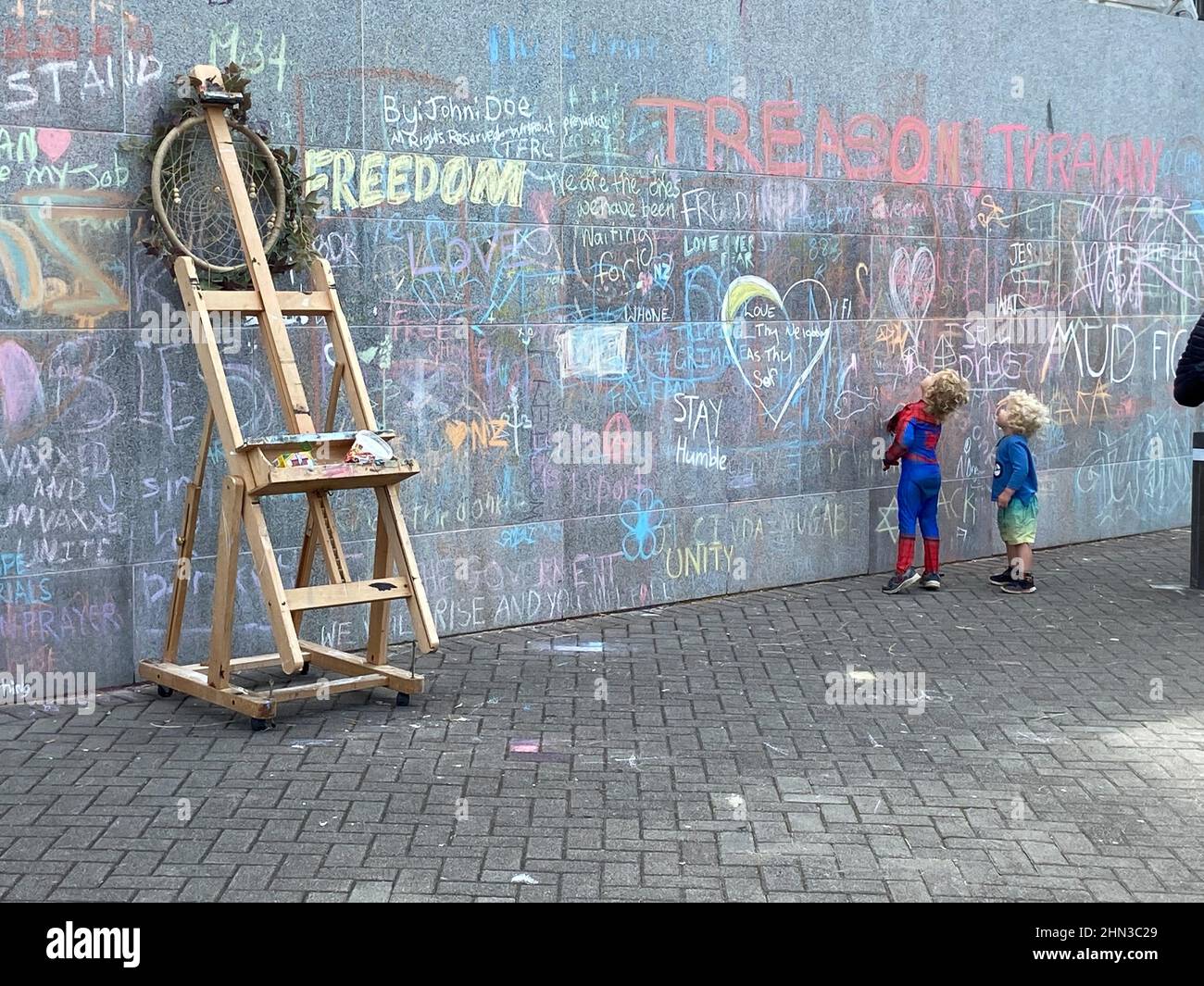 Children stand outside the parliament as protesters against the coronavirus disease (COVID-19) restrictions and vaccine mandates camp in front of it, in Wellington, New Zealand, February 14, 2022. REUTERS/Praveen Menon Stock Photo