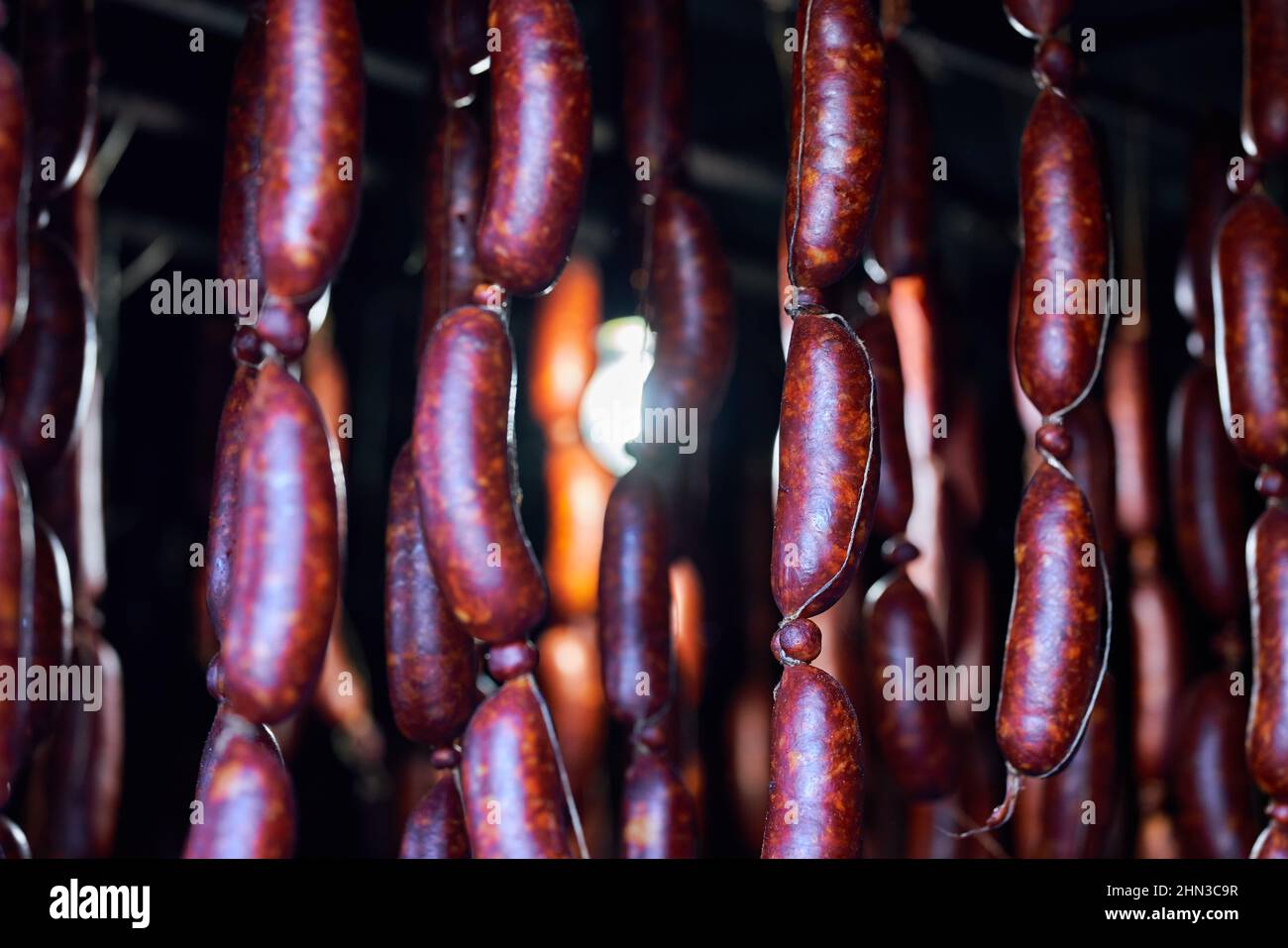 Freshly made sausages with pork and drying hanged with wood smoke and air. Stock Photo