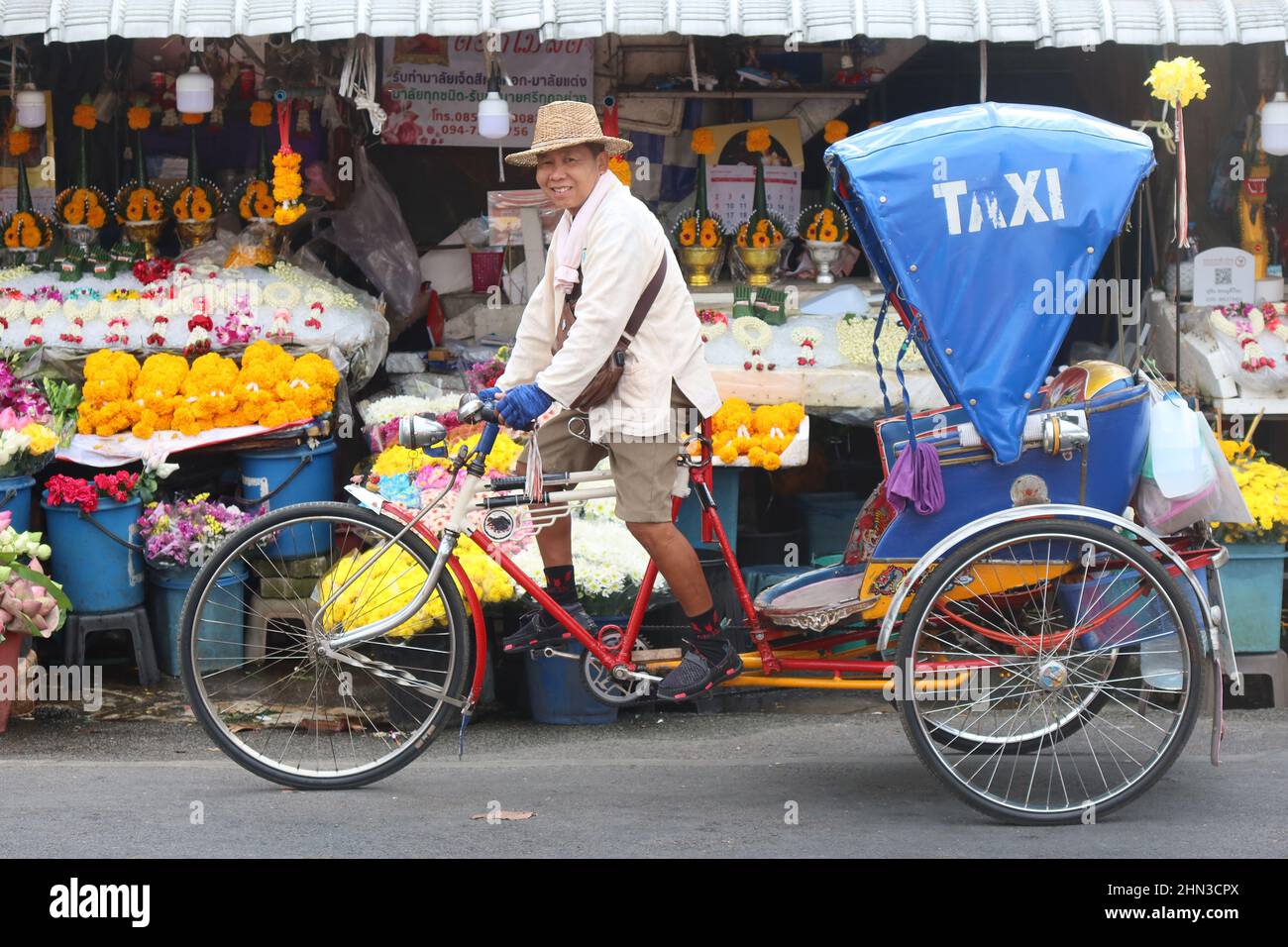 Smiling Rickshaw driver waiting for passenger at Chinatown market, Chinatown, Chiang Mai, Thailand Stock Photo